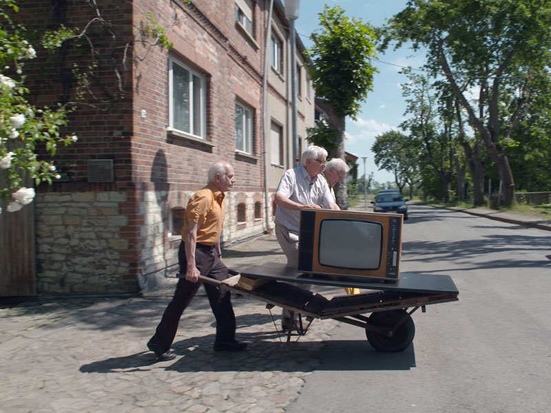Ein Fernseher wird auf einer Schubkarre transportiert
