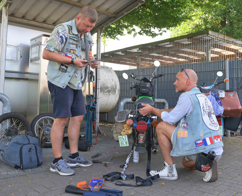 2 Männer reparieren ein Moped